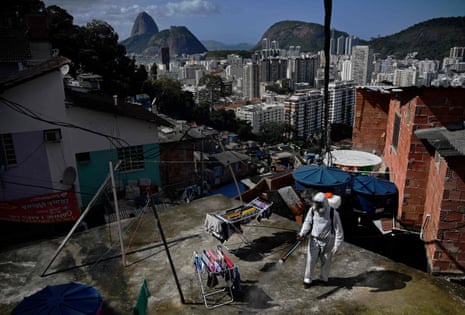 A volunteer disinfects a rooftop area inside Santa Marta Favela, in Rio de Janeiro, Brazil on 1 August, 2020, during the Covid-19 pandemic.