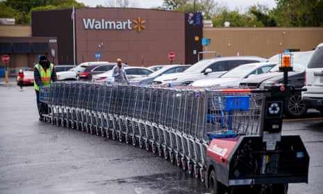A Walmart employee collects shopping carts in Alexandria, Virginia.