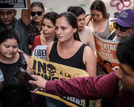 A group of worried looking people carrying signs.