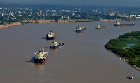 Ships line up in the Parana River as they wait to be loaded at the Port of Rosario in Argentina.