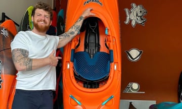 Bren Orton poses beside a kayak