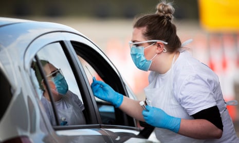 A member of Boots medical staff carries out a PCR swab at a drive-through test facility in Edinburgh