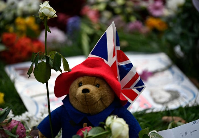 A Paddington Bear teddy bear is pictured with floral tributes in Green Park, London.