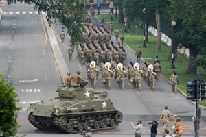 a tank and soldiers move along a street