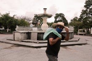 A man walks across Izúcar de Matamoros park wearing a mask.