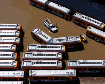 Aerial view of rows of buses surrounded by brown water.