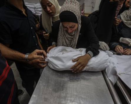 Relatives of Palestinians who lost their lives during Israeli attacks mourn during a funeral ceremony at al-Shifa hospital in Gaza City