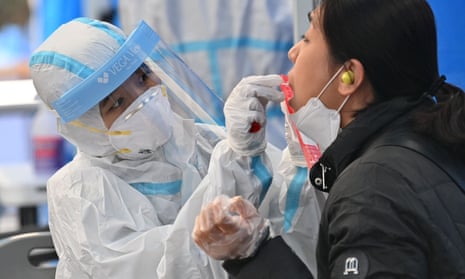 A health worker takes samples for a Covid-19 test from a woman at a testing station in Seoul.