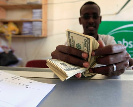 A bank worker counts US dollars