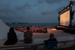 People watch the free cinema showings on the beach.