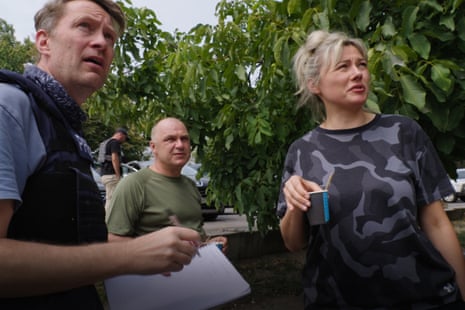 Journalist Luke Harding interviewing resident in Nikopol, Ukraine wearing press flak jacket