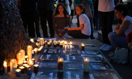 Young people gathered around a candle-lit vigil.