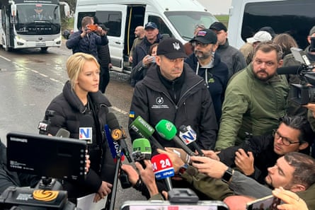 Ukraine’s and Russia’s human rights commissioners speaking to journalists as they arae crowded with microphones