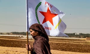 A Syrian Kurdish woman waves the flag of the Democratic Union Party during a demonstration near the town of Tel Arqam near the Turkish border on 6 October 2019.
