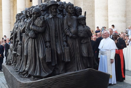 Pope Francis looks at the sculpture