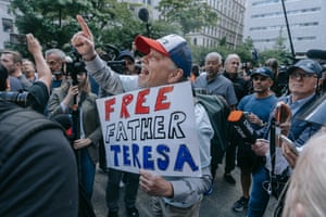 A Pro-Trump protester carrying a “Free Father Theresa” placard breaks down in tears outside the courthouse.