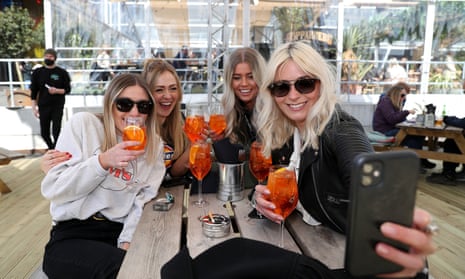 A group of women take a selfie as they enjoy a drink at a bar in Manchester.