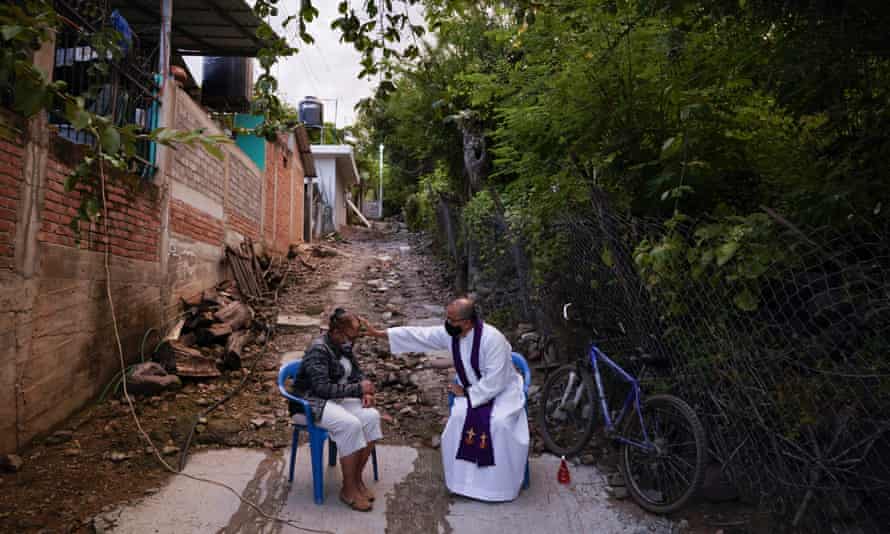 Mexico army gives drug cartels free rein as critics claim ‘non-aggression pact’ | Mexico 3 The Rev Gilberto Vergara blesses a person giving confession in Aguililla, Michoacán.