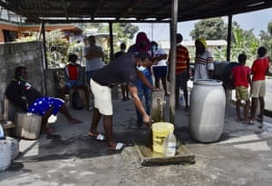 Volcanic ash covers St Vincent – in pictures 8 People collect uncontaminated water.