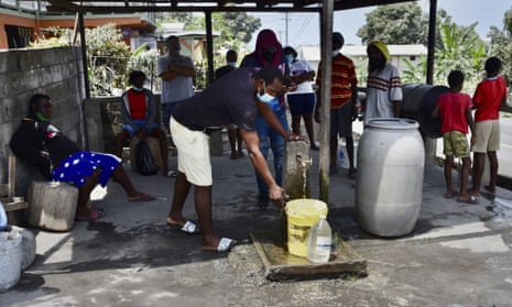 People collect clean water from a standpipe in Wallilabou after volcanic ash contaminated their supplies