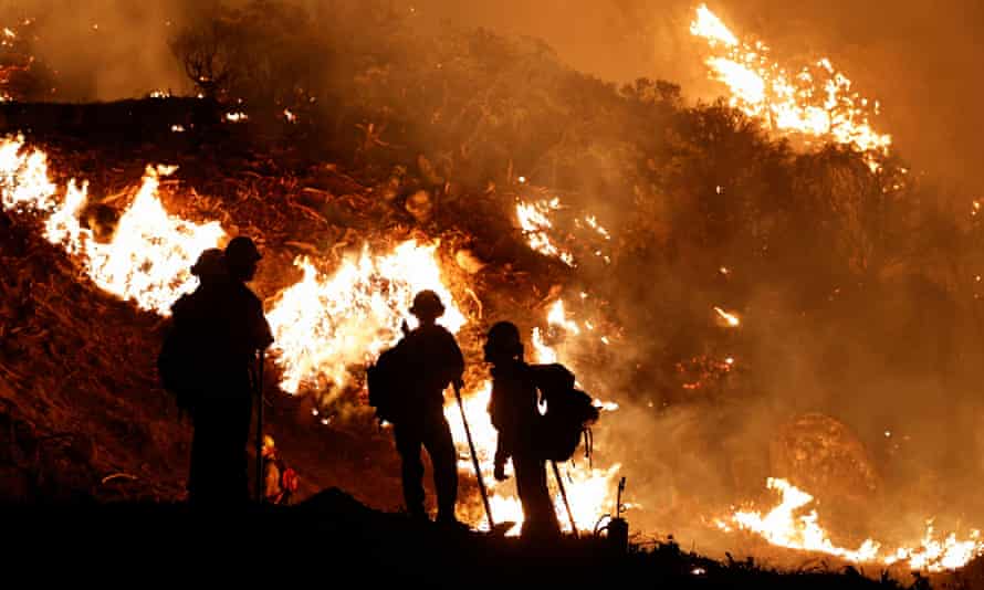 Firefighters watch backfires used to slow the spread of the Caldor Fire in Grizzly Flats, California, on Sunday.