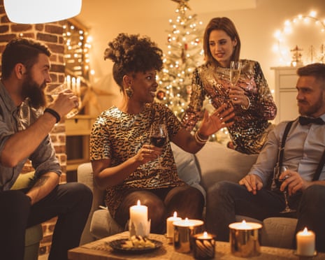 Friends celebrate new yearGroup of friends having a party at home. Sitting on sofa, dressed fancy. Drinking wine, eating cake, talking and laughing. Evening.