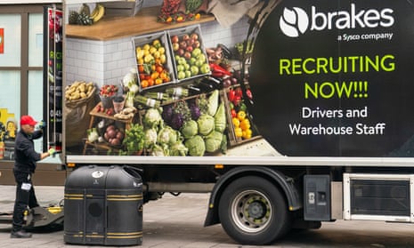  An advert for drivers and warehouse staff is displayed on the side of a lorry as a driver makes a delivery in central London.  