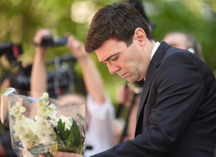 Burnham putting down a bouquet of white flowers
