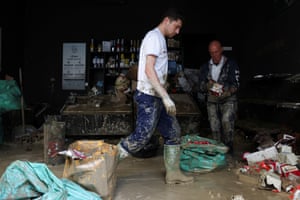 Pessoas limpam escombros de cafeteria em Faenza