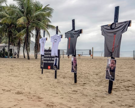 Four crosses with T-shirts and photos attached on a tropical beach