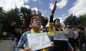 A woman holds a sign that reads in Spanish ‘Galápagos is not to be sold, but to be defended’ during a protest agains plans to allow the US military to use an island.