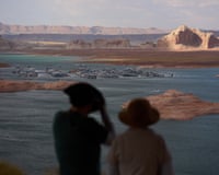 Two people out of focus look out toward water with spots of land showing