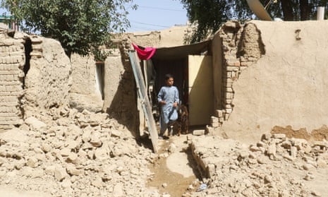 A boy walks out of his damaged family house, following an earthquake, in Harnai, Balochistan, Pakistan.