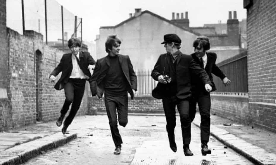 The Beatles running down a street