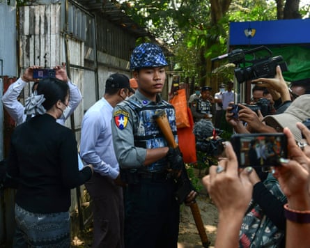 Burmese policeman with journalists around, some taking pictures