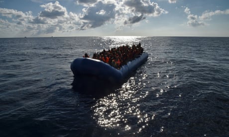 Migrants and refugees seated on a rubber boat wait to be evacuated during a rescue operation by the crew of the Topaz Responder, a rescue ship run by Maltese NGO "Moas" and the Italian Red Cross, on November 4, 2016 off the Libyan coast.