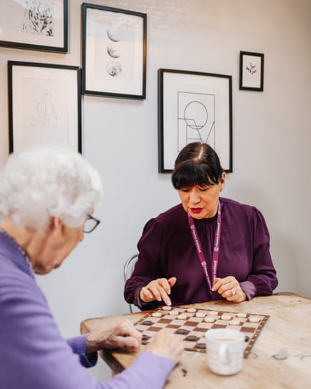 Carer playing checkers with older woman