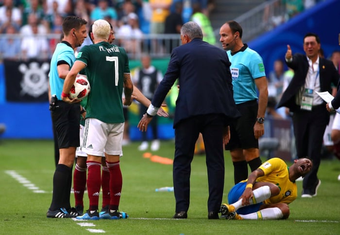 Brazil’s Neymar reacts as he holds his leg while Mexico’s Miguel Layun looks on.