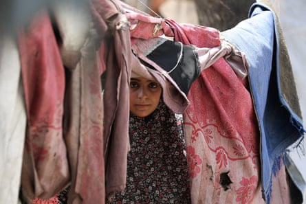 A Palestinian woman, displaced by the Israeli offensive, shelters in a tent camp in Gaza City.