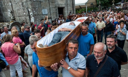 The faithful who consider themselves saved from death by the Santa Marta are carried in coffins during the procession