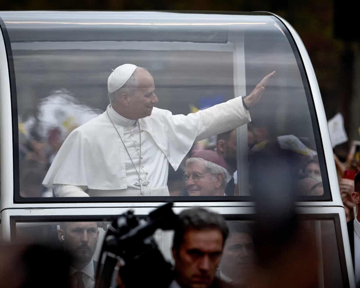 Pope Leo greets crowds lining the Champs-Élysées on the second day of his visit to France