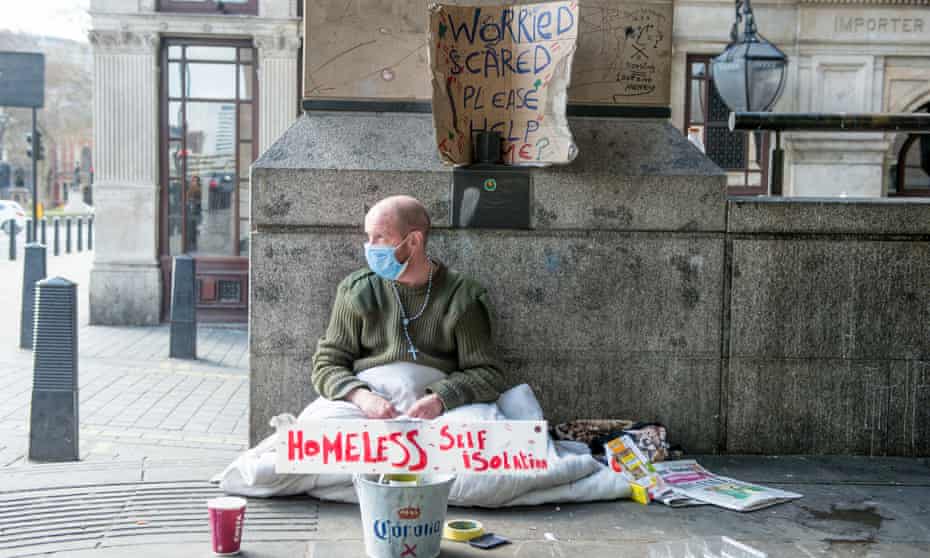 A homeless man sits against a wall in Westminster near Downing Street with a sign that reads ‘Homeless Self Isolating’ during England’s first lockdown in April.
