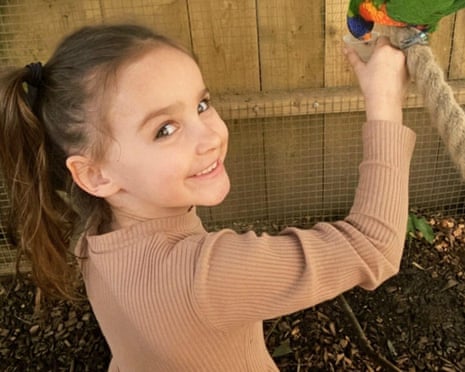 Aria Thorpe smiles as she feeds a bird in a zoo