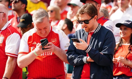 Arsenal fans nervously check the score between Man City and West Ham on the final day of the season.