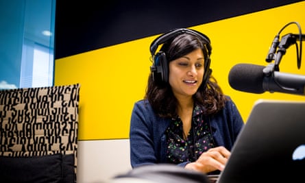 Anushka Asthana in front of a microphone in a brightly coloured yellow, white and black studio booth