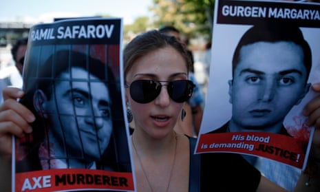 An Armenian protester holds pictures of Ramil Safarov, left, and Gurgen Margaryan during a demonstration outside the Hungarian embassy in Nicosia, Cyprus, in 2012