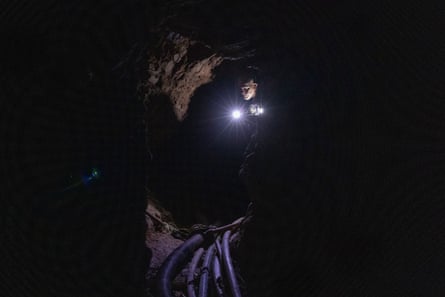 Nilton Tubino uses a torch to illuminate an underground tunnel