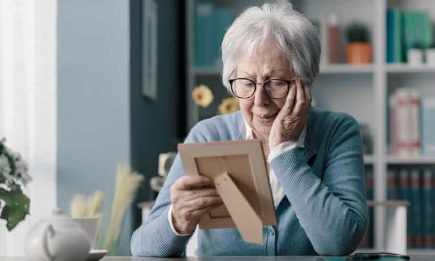 woman looks at photograph of dead loved one