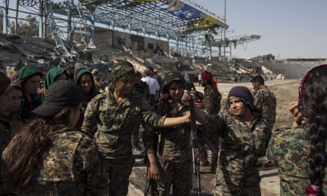Members of the Syrian Democratic Forces celebrate at a stadium that was the site of Islamic State fighters’ last stand in the city of Raqqa.
