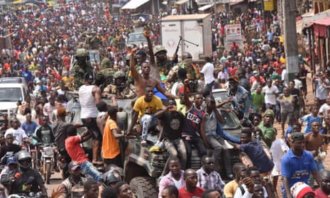 People celebrate in the streets of Conakry with members of Guinea’s armed forces after the arrest of Alpha Condé.